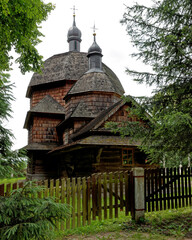 Old wooden church architecture in Hrebenne. Fence in front. Roztocze, Poland, Europe.