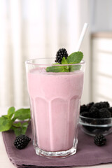 Tasty blackberry milk shake with fresh berries on table