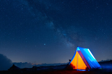 Tent glowing under the milky way at night. Camping in the mountains under the starry magical sky. 5 Billion Star Hotel. © Pol Solé