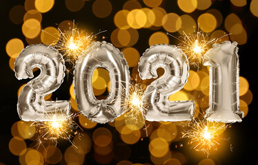 2021 New Year celebration. Bright balloons with sparklers and blurred lights on dark background