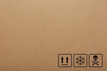 Cardboard box with packaging symbols as background, closeup