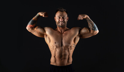 Fototapeta na wymiar Male bodybuilder on dark background, studio shot