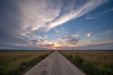 View down a rural road at sunset.