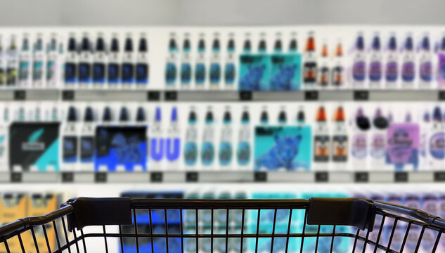 Abstract blurred image of alcohol store with trolley (Selective focused at shopping cart)