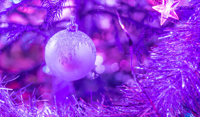Purple festive Christmas background with xmas ball and tinsel on Christmas Tree. Copy space,...