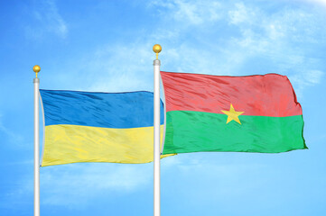 Ukraine and Burkina Faso two flags on flagpoles and blue sky