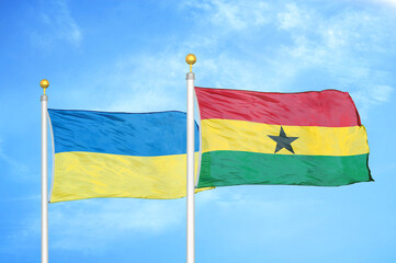 Ukraine and Ghana two flags on flagpoles and blue sky