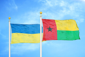 Ukraine and Guinea-Bissau two flags on flagpoles and blue sky
