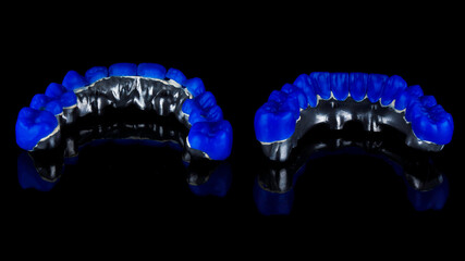 wax up on titanium bars with blue wax teeth of the lower and upper jaws, view from the inside on black glass with a beautiful reflection © Dental Pro Content