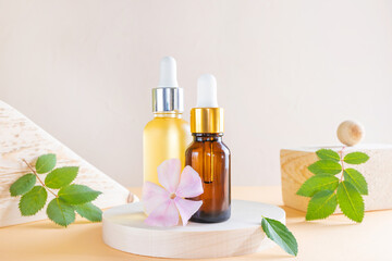 Cosmetic natural oil in a transparent bottles with a dispenser, wooden square and round. Wood,...