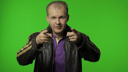 Handsome positive rocker man in brown denim jacket pointing finger at camera. Chroma key