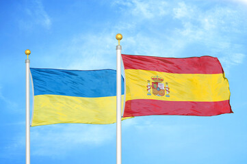 Ukraine and Spain two flags on flagpoles and blue sky