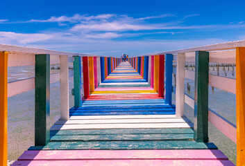 Rainbow bridge in Thailand.View of The colorful wood bridge extends into the sea under blue sky at...