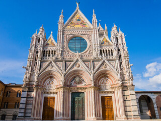 Fototapeta na wymiar Stunning view of Siena Cathedral main facade, a medieval church now dedicated to catholic Assumption of Mary, Tuscany, Italy 