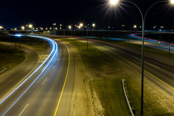 Fototapeta na wymiar Light trails from vehicles travelling on the Circle Drive freeway late at night in Saskatoon, Saskatchewan Canada