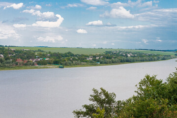 Arial view over small village near the river. City skyline background.