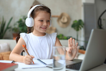 Little girl studing online with video call teacher. Distance learning in epidemic of Covid-19...