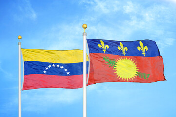 Venezuela and Guadeloupe two flags on flagpoles and blue sky