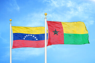 Venezuela and Guinea-Bissau two flags on flagpoles and blue sky