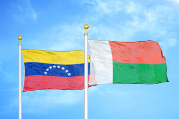 Fototapeta na wymiar Venezuela and Madagascar two flags on flagpoles and blue sky