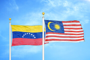 Venezuela and Malaysia two flags on flagpoles and blue sky