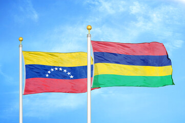 Venezuela and Mauritius two flags on flagpoles and blue sky