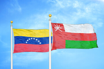 Venezuela and Oman two flags on flagpoles and blue sky