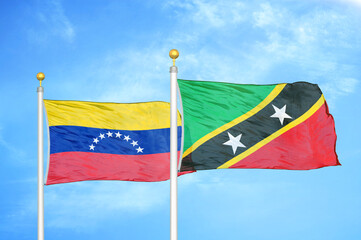 Venezuela and Saint Kitts and Nevis two flags on flagpoles and blue sky