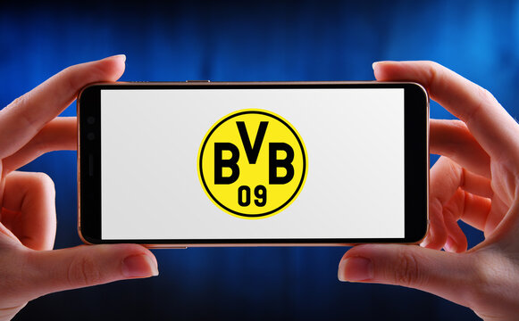 Hand Holding Smartphone Displaying Logo Of Borussia Dortmund