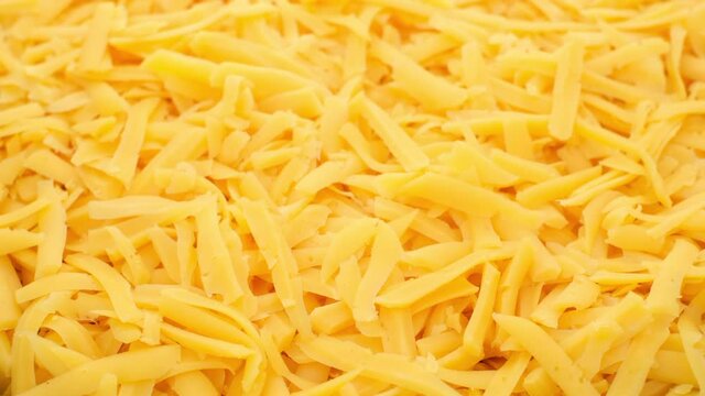 grated cheddar cheese rotating top view. grated cheese for pizza, pasta
