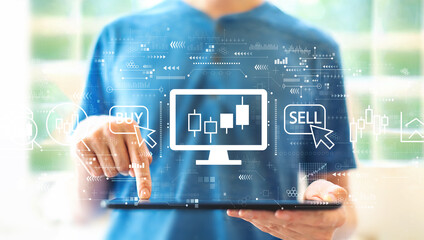 Stock trading theme with young man using a tablet computer