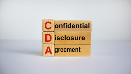 Concept words 'CDA, confidential disclosure agreement' on cubes on a beautiful blue background. Business concept, copy space.