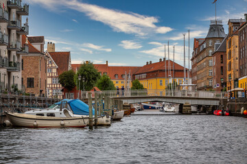 Photo of Copenhagen tourist landmark spot taken during a boat ride across the city canals, on a hot summer day with bright sky.