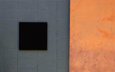Black copy space on a blank signboard. It can be used for the mockup of the Store logo, restaurant, office, etc., including use for advertising media. With a rusting orange iron door on the right.