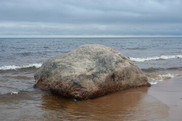 Large granite boulder on coast of lake.