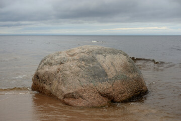Large granite boulder on coast of lake.