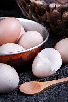 Close-up image of several unbroken eggs next to a broken egg