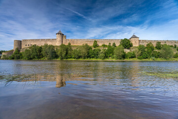 Naklejka na ściany i meble Narva, on the Narva river, at the eastern extreme point of Estonia, at the Russian border. The Narva Castle towers over the Estonian side, while Ivangorod Fortress sprawls across the Russian bank.