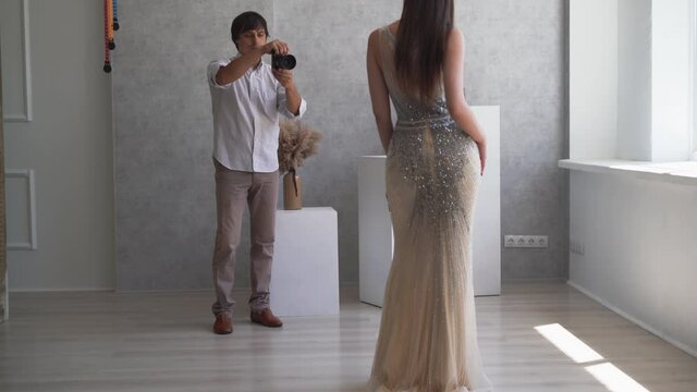guy photographer conducts a photo session for the model. take a portrait with natural light.