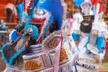 Masked morenada dancer in ornate costumes parade through the mining city of Oruro on the Altiplano of Bolivia during the annual carnival.