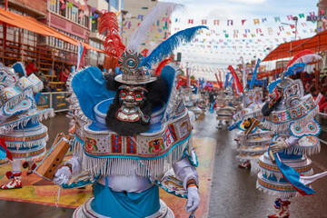 Maskierte Morenada-Tänzerin in kunstvollen Kostümen ziehen während des jährlichen Karnevals durch die Bergbaustadt Oruro auf dem Altiplano von Bolivien.
