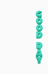 Text of GOOD DAY spelled with aqua blue alphabet shaped cookies on a white background