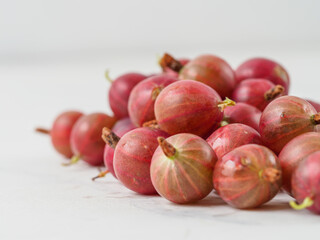 Fresh gooseberry on white wooden background.