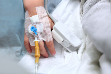 A child's hand with a catheter-dropper. Introduction to General anesthesia before surgery. Unrecognizable macro photo. Copy of the space. - obrazy, fototapety, plakaty