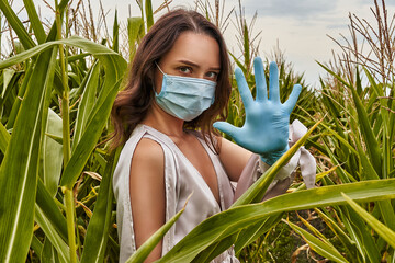 Beautiful girl with protective mask on face and medical gloves in cornfield. Stop coronavirus epidemic, COVID-19 quarantine concept, social distancing