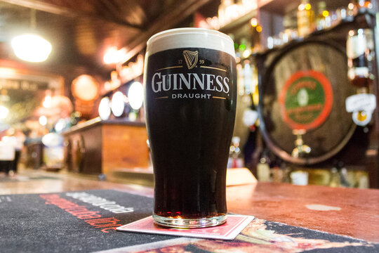 A pint of Irish dry stout Guinness over the counter of The House of McDonnell, a traditional pub in Ballycastle, County Antrim, Northern Ireland