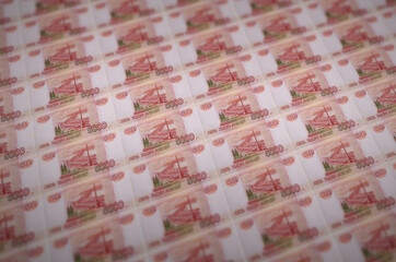 5000 russian rubles bills printed in illegal money production conveyor. Collage of many fake bills....