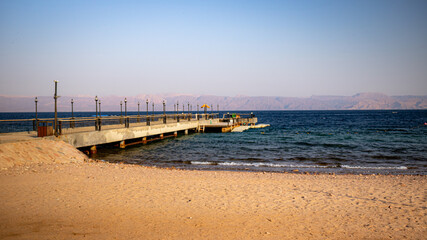 Obraz premium Pier on beach, daylight pier, Beach view, umbrella on beach, cheers on beach 