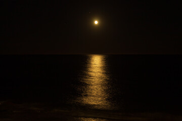 Fototapeta na wymiar Full Moon over the sea in Bussana, Italy