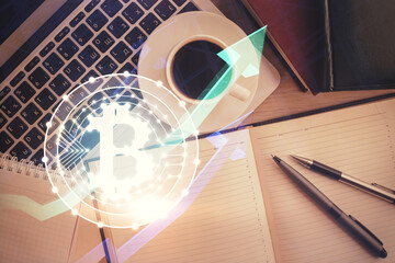 Blockchain theme hologram drawings over computer on the desktop background. Top view. Double...
